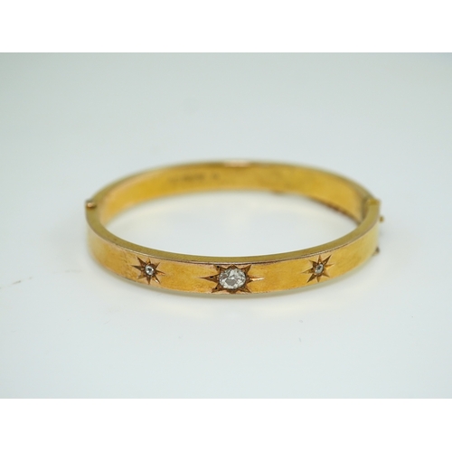 232 - An Edwardian 15ct gold and diamond bangle, circa 1904, the hinged bangle set to the front with a seq... 