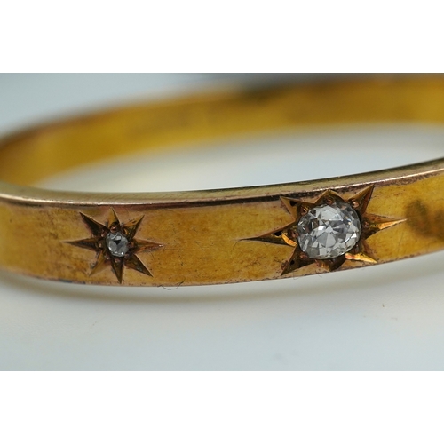 232 - An Edwardian 15ct gold and diamond bangle, circa 1904, the hinged bangle set to the front with a seq... 