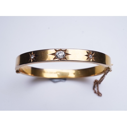 232 - An Edwardian 15ct gold and diamond bangle, circa 1904, the hinged bangle set to the front with a seq... 