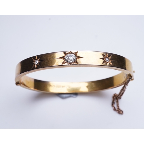 232 - An Edwardian 15ct gold and diamond bangle, circa 1904, the hinged bangle set to the front with a seq... 