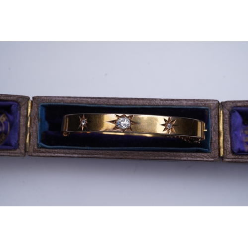 232 - An Edwardian 15ct gold and diamond bangle, circa 1904, the hinged bangle set to the front with a seq... 