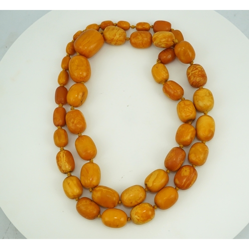 234 - A single strand graduated oval amber bead necklace, length 104cm, gross weight 163 grams