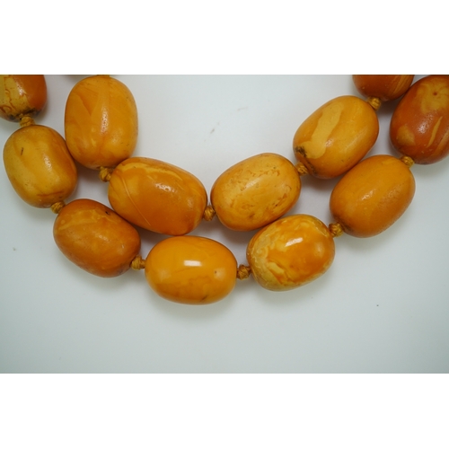 234 - A single strand graduated oval amber bead necklace, length 104cm, gross weight 163 grams