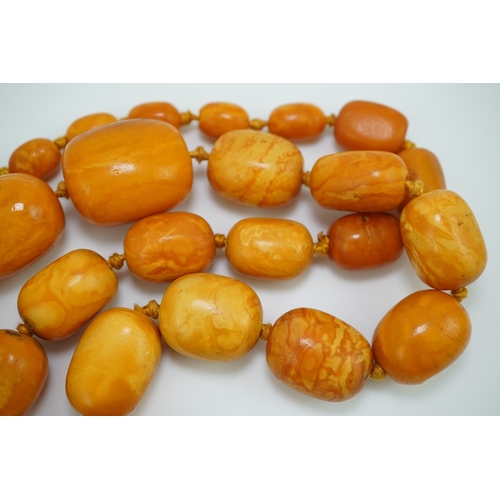 234 - A single strand graduated oval amber bead necklace, length 104cm, gross weight 163 grams