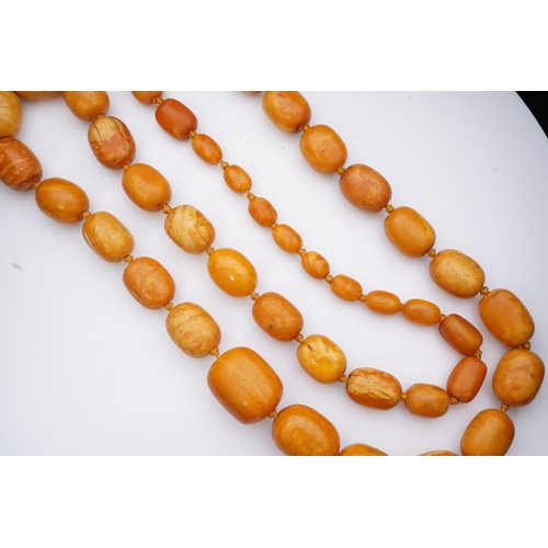 234 - A single strand graduated oval amber bead necklace, length 104cm, gross weight 163 grams