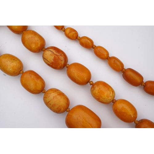 234 - A single strand graduated oval amber bead necklace, length 104cm, gross weight 163 grams