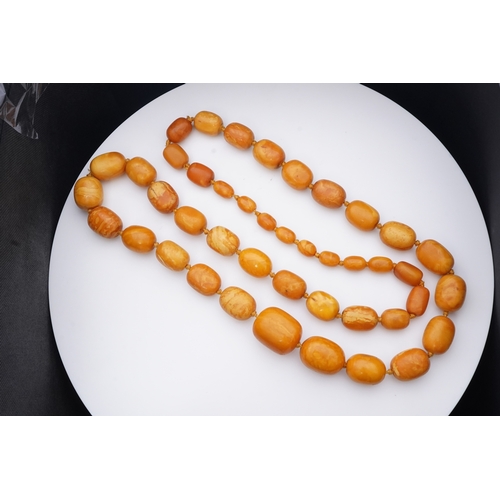 234 - A single strand graduated oval amber bead necklace, length 104cm, gross weight 163 grams