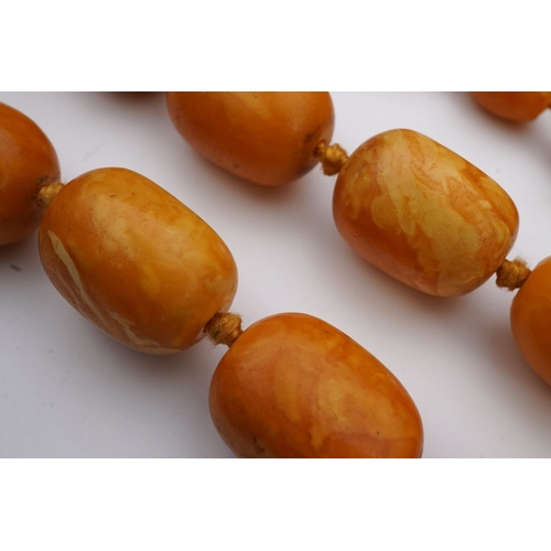 234 - A single strand graduated oval amber bead necklace, length 104cm, gross weight 163 grams