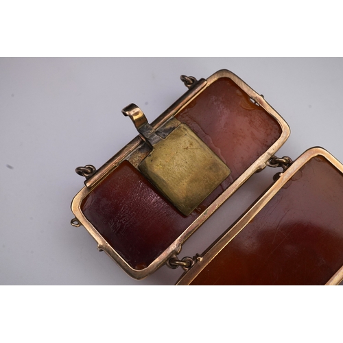 235 - A gold and amber bracelet, composed of panels of amber carved with scroll motifs, mounted in gold, l... 