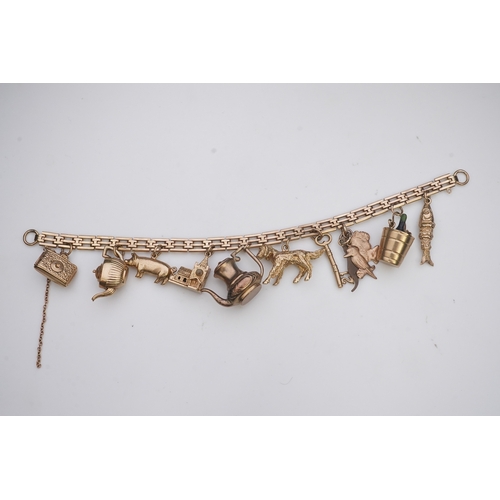 243 - A charm bracelet, mid 20th century, the 9ct gate link bracelet suspending a series of twelve charms ... 