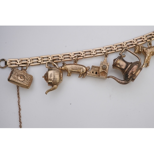 243 - A charm bracelet, mid 20th century, the 9ct gate link bracelet suspending a series of twelve charms ... 