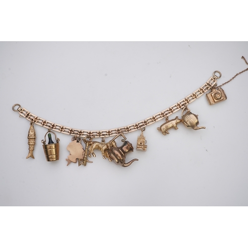 243 - A charm bracelet, mid 20th century, the 9ct gate link bracelet suspending a series of twelve charms ... 