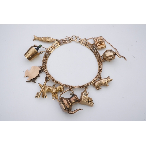 243 - A charm bracelet, mid 20th century, the 9ct gate link bracelet suspending a series of twelve charms ... 