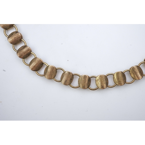 253 - A gold necklace, circa 2000, composed of textured 9ct gold linking, to a clasp accented with a brill... 