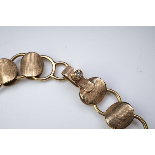 253 - A gold necklace, circa 2000, composed of textured 9ct gold linking, to a clasp accented with a brill... 