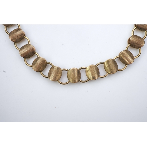 253 - A gold necklace, circa 2000, composed of textured 9ct gold linking, to a clasp accented with a brill... 