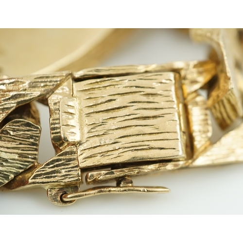 260 - A 9ct gold identity bracelet, circa 1973, composed of heavy curb linking with a textured finish, cen... 