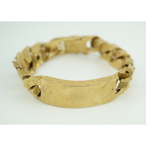 260 - A 9ct gold identity bracelet, circa 1973, composed of heavy curb linking with a textured finish, cen... 