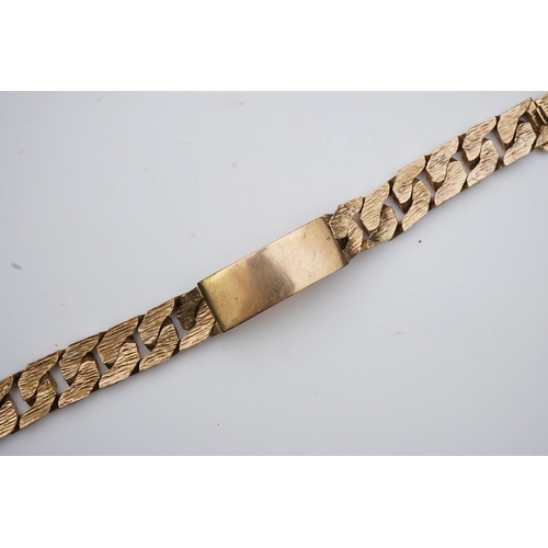 260 - A 9ct gold identity bracelet, circa 1973, composed of heavy curb linking with a textured finish, cen... 