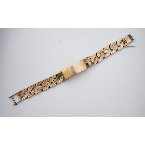 260 - A 9ct gold identity bracelet, circa 1973, composed of heavy curb linking with a textured finish, cen... 