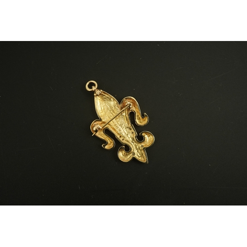 262 - A gold and diamond pendant/brooch, designed as a fleur-de-lis, the letter 'M' pavé-set with brillian... 