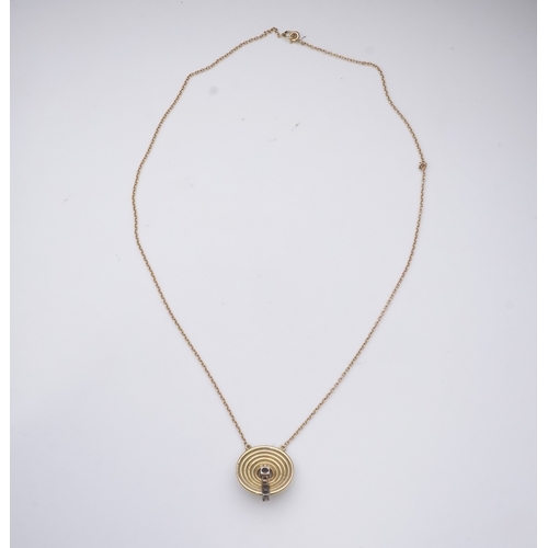 265 - An 18ct gold and diamond pendant, circa 1978, designed as a grooved disc set with a line of graduate... 