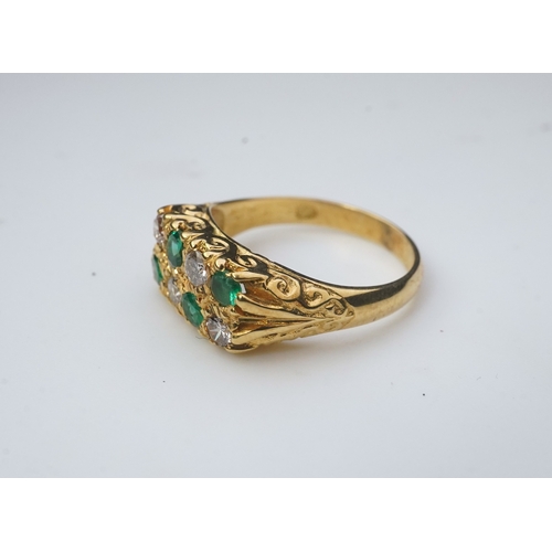 283 - An emerald and diamond ring, circa 1975, designed in the Victorian style, set with two lines of bril... 