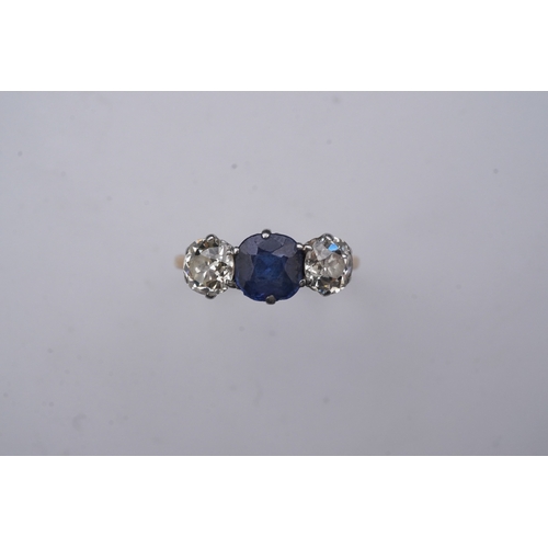 287 - A sapphire and diamond three-stone ring, early 20th century, claw-set with a cushion-shaped sapphire... 