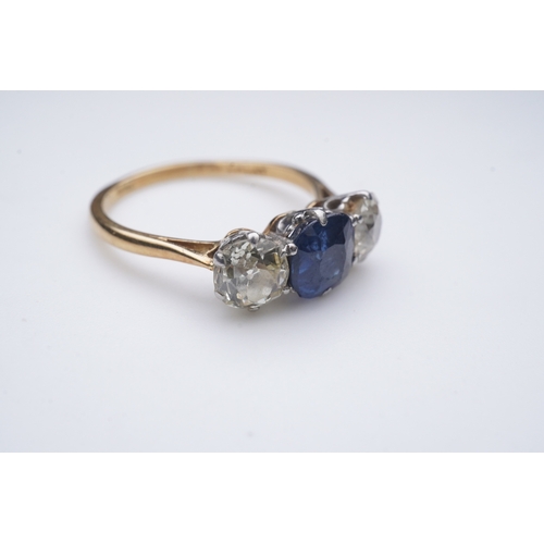 287 - A sapphire and diamond three-stone ring, early 20th century, claw-set with a cushion-shaped sapphire... 