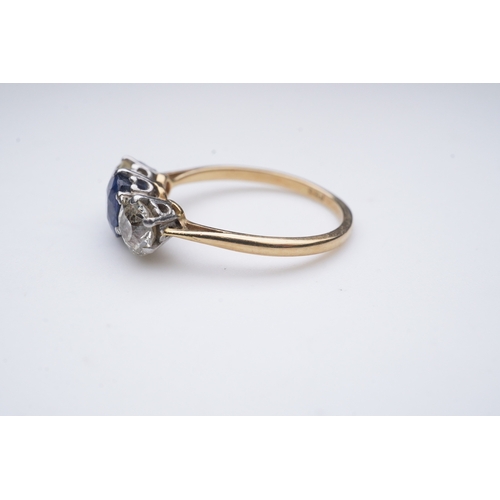 287 - A sapphire and diamond three-stone ring, early 20th century, claw-set with a cushion-shaped sapphire... 