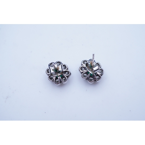 294 - A pair of emerald and diamond earrings, each of cluster design, set with an oval emerald within a mi... 