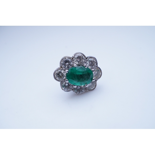 294 - A pair of emerald and diamond earrings, each of cluster design, set with an oval emerald within a mi... 