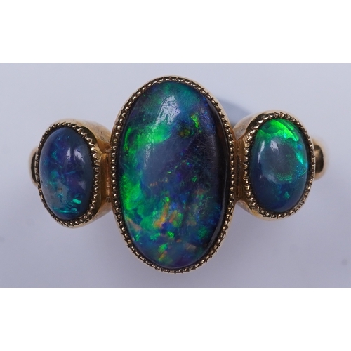 304 - A Victorian black opal ring, circa 1881, set with three cabochon black opals, mounted in 18ct gold, ... 