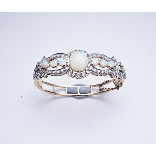 308 - An opal and diamond bangle, of hinged design, the front set with cabochon and heart-shaped opals wit... 