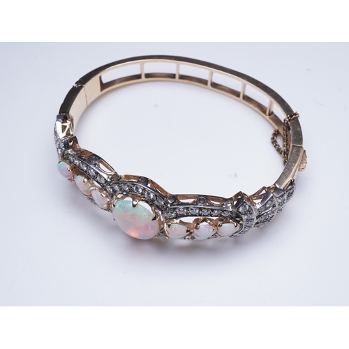 308 - An opal and diamond bangle, of hinged design, the front set with cabochon and heart-shaped opals wit... 