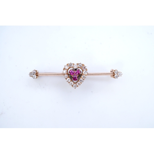 312 - An Edwardian ruby and diamond brooch, centring on a heart motif set with cushion-shaped rubies and c... 