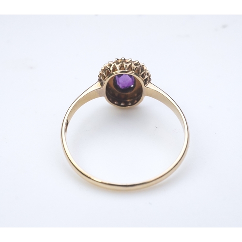 313 - An Edwardian amethyst and seed pearl ring, early 20th century, of cluster design, set with an oval a... 