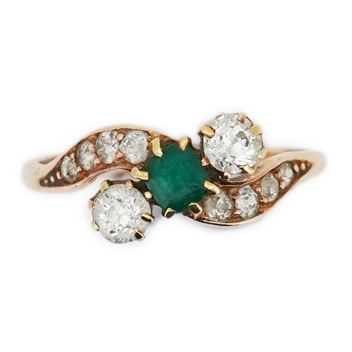 314 - An emerald & diamond ring, early 20th century, of crossover design, set with a step-cut emerald betw... 