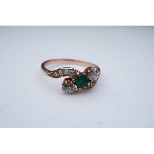 314 - An emerald & diamond ring, early 20th century, of crossover design, set with a step-cut emerald betw... 