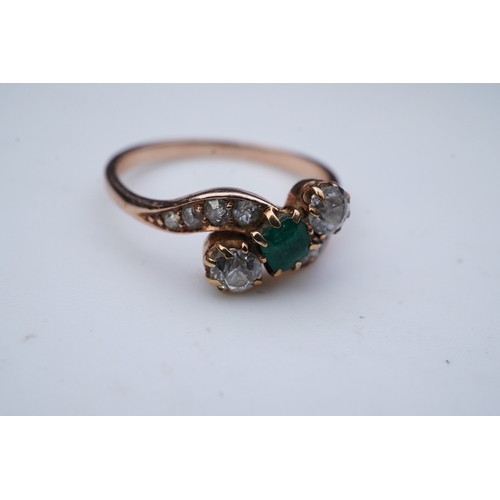 314 - An emerald & diamond ring, early 20th century, of crossover design, set with a step-cut emerald betw... 