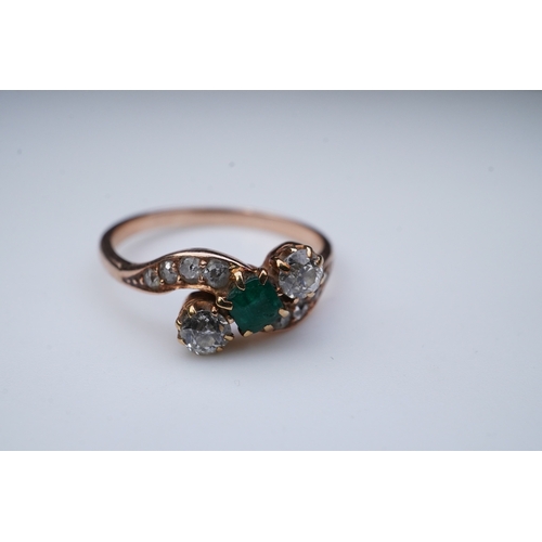 314 - An emerald & diamond ring, early 20th century, of crossover design, set with a step-cut emerald betw... 