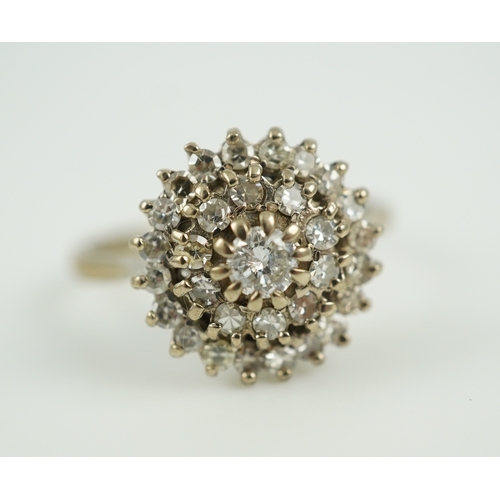 317 - A diamond ring, of cluster design, set with a brilliant-cut diamond within two concentric bands of s... 