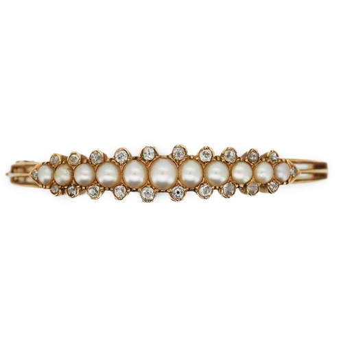 319 - An Edwardian pearl and diamond bangle, early 20th century, the hinged bangle of knifewire constructi... 