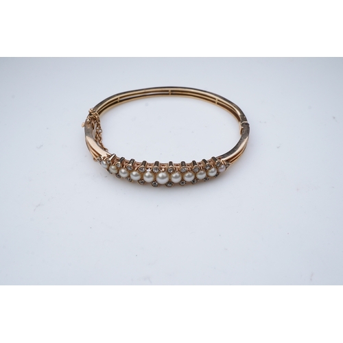 319 - An Edwardian pearl and diamond bangle, early 20th century, the hinged bangle of knifewire constructi... 