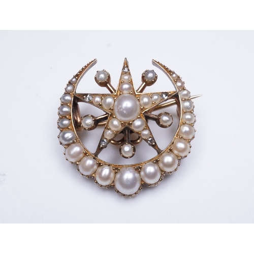 322 - An Edwardian half pearl and diamond brooch, early 20th century, designed as a crescent moon enclosin... 