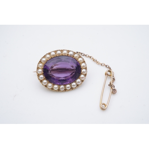 330 - An amethyst and split pearl brooch, circa 1900, of oval outline, set with an oval amethyst within a ... 