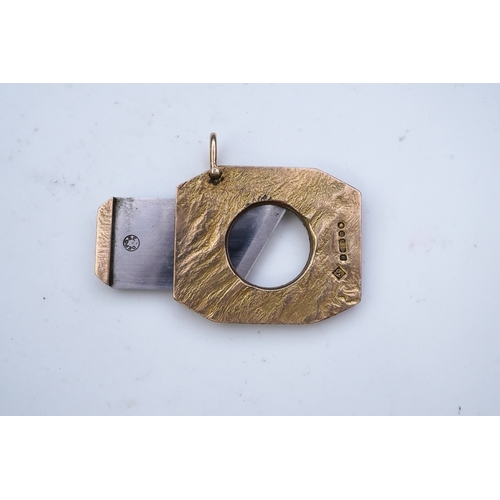 347 - Dunhill, a 9ct gold and steel cigar cutter, circa 1968, with a samorodok-style finish enclosing a sl... 