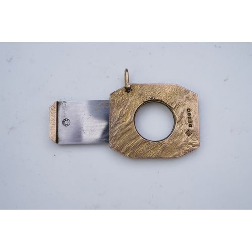 347 - Dunhill, a 9ct gold and steel cigar cutter, circa 1968, with a samorodok-style finish enclosing a sl... 