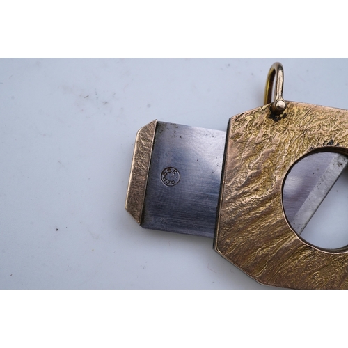 347 - Dunhill, a 9ct gold and steel cigar cutter, circa 1968, with a samorodok-style finish enclosing a sl... 