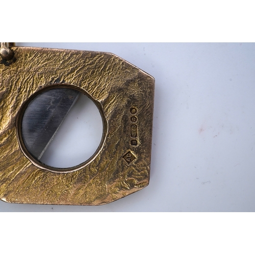 347 - Dunhill, a 9ct gold and steel cigar cutter, circa 1968, with a samorodok-style finish enclosing a sl... 